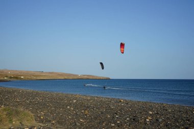 Kiteboardcular sörf tahtalarını Matas Körfezi 'ndeki Atlantik Okyanusu' nun dalgalarından geçiriyorlar. Uçurtma sörfü ya da uçurtma uçurmak rüzgar enerjisi gerektiren bir spordur. Costa Calma, Fuerteventura, Las Palmas, Kanarya Adaları, İspanya. 