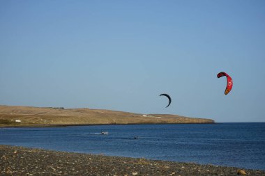 Kiteboardcular sörf tahtalarını Matas Körfezi 'ndeki Atlantik Okyanusu' nun dalgalarından geçiriyorlar. Uçurtma sörfü ya da uçurtma uçurmak rüzgar enerjisi gerektiren bir spordur. Costa Calma, Fuerteventura, Las Palmas, Kanarya Adaları, İspanya. 