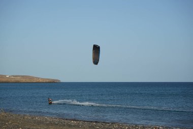 Bir uçurtma sörfçüsü, Matas Bay 'de, Matas de Blancas plajı boyunca sonbaharda Atlantik Okyanusu' nun dalgaları üzerinde sörf tahtasına biner. Uçurtma sörfü ya da uçurtma uçurmak rüzgar enerjisi gerektiren bir spordur. Costa Calma, Fuerteventura, Kanarya Adaları.  