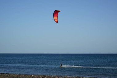 Bir uçurtma sörfçüsü, Matas Bay 'de, Matas de Blancas plajı boyunca sonbaharda Atlantik Okyanusu' nun dalgaları üzerinde sörf tahtasına biner. Uçurtma sörfü ya da uçurtma uçurmak rüzgar enerjisi gerektiren bir spordur. Costa Calma, Fuerteventura, Kanarya Adaları.  