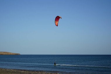 Bir uçurtma sörfçüsü, Matas Bay 'de, Matas de Blancas plajı boyunca sonbaharda Atlantik Okyanusu' nun dalgaları üzerinde sörf tahtasına biner. Uçurtma sörfü ya da uçurtma uçurmak rüzgar enerjisi gerektiren bir spordur. Costa Calma, Fuerteventura, Kanarya Adaları.  