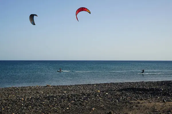 Kiteboardcular sörf tahtalarını Matas Körfezi 'ndeki Atlantik Okyanusu' nun dalgalarından geçiriyorlar. Uçurtma sörfü ya da uçurtma uçurmak rüzgar enerjisi gerektiren bir spordur. Costa Calma, Fuerteventura, Las Palmas, Kanarya Adaları, İspanya. 