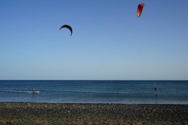 Kiteboardcular sörf tahtalarını Matas Körfezi 'ndeki Atlantik Okyanusu' nun dalgalarından geçiriyorlar. Uçurtma sörfü ya da uçurtma uçurmak rüzgar enerjisi gerektiren bir spordur. Costa Calma, Fuerteventura, Las Palmas, Kanarya Adaları, İspanya. 