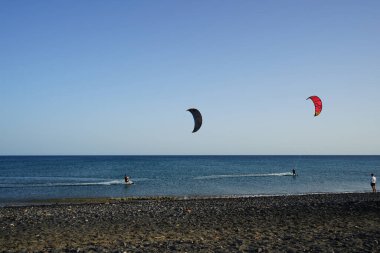 Kiteboardcular sörf tahtalarını Matas Körfezi 'ndeki Atlantik Okyanusu' nun dalgalarından geçiriyorlar. Uçurtma sörfü ya da uçurtma uçurmak rüzgar enerjisi gerektiren bir spordur. Costa Calma, Fuerteventura, Las Palmas, Kanarya Adaları, İspanya. 