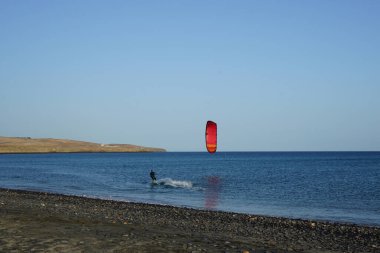 Bir uçurtma sörfçüsü, Matas Bay 'de, Matas de Blancas plajı boyunca sonbaharda Atlantik Okyanusu' nun dalgaları üzerinde sörf tahtasına biner. Uçurtma sörfü ya da uçurtma uçurmak rüzgar enerjisi gerektiren bir spordur. Costa Calma, Fuerteventura, Kanarya Adaları.  