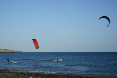 Kiteboardcular sörf tahtalarını Matas Körfezi 'ndeki Atlantik Okyanusu' nun dalgalarından geçiriyorlar. Uçurtma sörfü ya da uçurtma uçurmak rüzgar enerjisi gerektiren bir spordur. Costa Calma, Fuerteventura, Las Palmas, Kanarya Adaları, İspanya. 
