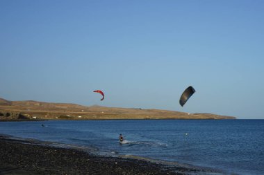 Kiteboardcular sörf tahtalarını Matas Körfezi 'ndeki Atlantik Okyanusu' nun dalgalarından geçiriyorlar. Uçurtma sörfü ya da uçurtma uçurmak rüzgar enerjisi gerektiren bir spordur. Costa Calma, Fuerteventura, Las Palmas, Kanarya Adaları, İspanya. 