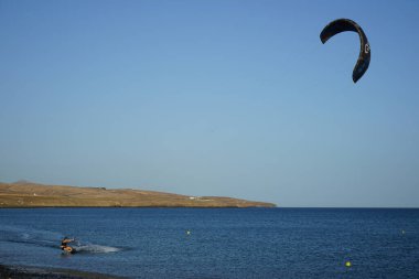 Bir uçurtma sörfçüsü, Matas Bay 'de, Matas de Blancas plajı boyunca sonbaharda Atlantik Okyanusu' nun dalgaları üzerinde sörf tahtasına biner. Uçurtma sörfü ya da uçurtma uçurmak rüzgar enerjisi gerektiren bir spordur. Costa Calma, Fuerteventura, Kanarya Adaları.  