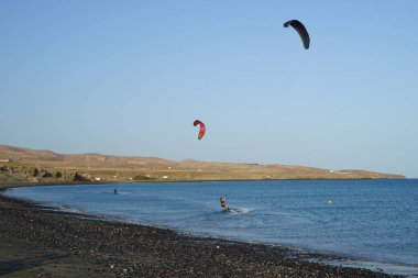 Kiteboardcular sörf tahtalarını Matas Körfezi 'ndeki Atlantik Okyanusu' nun dalgalarından geçiriyorlar. Uçurtma sörfü ya da uçurtma uçurmak rüzgar enerjisi gerektiren bir spordur. Costa Calma, Fuerteventura, Las Palmas, Kanarya Adaları, İspanya. 