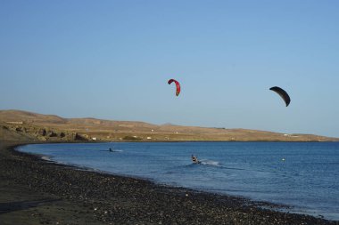 Kiteboardcular sörf tahtalarını Matas Körfezi 'ndeki Atlantik Okyanusu' nun dalgalarından geçiriyorlar. Uçurtma sörfü ya da uçurtma uçurmak rüzgar enerjisi gerektiren bir spordur. Costa Calma, Fuerteventura, Las Palmas, Kanarya Adaları, İspanya. 