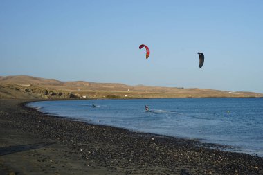 Kiteboardcular sörf tahtalarını Matas Körfezi 'ndeki Atlantik Okyanusu' nun dalgalarından geçiriyorlar. Uçurtma sörfü ya da uçurtma uçurmak rüzgar enerjisi gerektiren bir spordur. Costa Calma, Fuerteventura, Las Palmas, Kanarya Adaları, İspanya. 