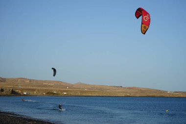 Kiteboardcular sörf tahtalarını Matas Körfezi 'ndeki Atlantik Okyanusu' nun dalgalarından geçiriyorlar. Uçurtma sörfü ya da uçurtma uçurmak rüzgar enerjisi gerektiren bir spordur. Costa Calma, Fuerteventura, Las Palmas, Kanarya Adaları, İspanya. 