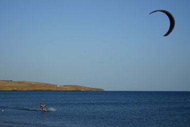 Bir uçurtma sörfçüsü, Matas Bay 'de, Matas de Blancas plajı boyunca sonbaharda Atlantik Okyanusu' nun dalgaları üzerinde sörf tahtasına biner. Uçurtma sörfü ya da uçurtma uçurmak rüzgar enerjisi gerektiren bir spordur. Costa Calma, Fuerteventura, Kanarya Adaları.  