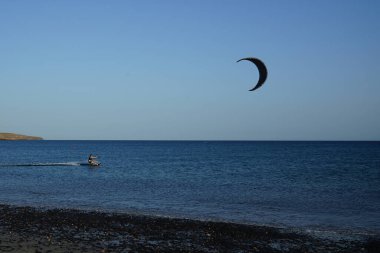 Bir uçurtma sörfçüsü, Matas Bay 'de, Matas de Blancas plajı boyunca sonbaharda Atlantik Okyanusu' nun dalgaları üzerinde sörf tahtasına biner. Uçurtma sörfü ya da uçurtma uçurmak rüzgar enerjisi gerektiren bir spordur. Costa Calma, Fuerteventura, Kanarya Adaları.  