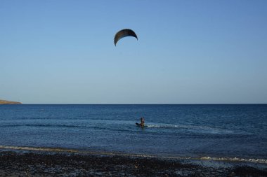 Bir uçurtma sörfçüsü, Matas Bay 'de, Matas de Blancas plajı boyunca sonbaharda Atlantik Okyanusu' nun dalgaları üzerinde sörf tahtasına biner. Uçurtma sörfü ya da uçurtma uçurmak rüzgar enerjisi gerektiren bir spordur. Costa Calma, Fuerteventura, Kanarya Adaları.  