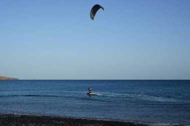 Bir uçurtma sörfçüsü, Matas Bay 'de, Matas de Blancas plajı boyunca sonbaharda Atlantik Okyanusu' nun dalgaları üzerinde sörf tahtasına biner. Uçurtma sörfü ya da uçurtma uçurmak rüzgar enerjisi gerektiren bir spordur. Costa Calma, Fuerteventura, Kanarya Adaları.  