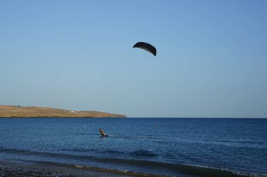 Bir uçurtma sörfçüsü, Matas Bay 'de, Matas de Blancas plajı boyunca sonbaharda Atlantik Okyanusu' nun dalgaları üzerinde sörf tahtasına biner. Uçurtma sörfü ya da uçurtma uçurmak rüzgar enerjisi gerektiren bir spordur. Costa Calma, Fuerteventura, Kanarya Adaları.  