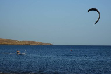 Bir uçurtma sörfçüsü, Matas Bay 'de, Matas de Blancas plajı boyunca sonbaharda Atlantik Okyanusu' nun dalgaları üzerinde sörf tahtasına biner. Uçurtma sörfü ya da uçurtma uçurmak rüzgar enerjisi gerektiren bir spordur. Costa Calma, Fuerteventura, Kanarya Adaları.  