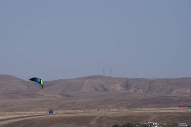 Bir uçurtma sörfçüsü, Matas Bay 'de, Matas de Blancas plajı boyunca sonbaharda Atlantik Okyanusu' nun dalgaları üzerinde sörf tahtasına biner. Uçurtma sörfü ya da uçurtma uçurmak rüzgar enerjisi gerektiren bir spordur. Costa Calma, Fuerteventura, Kanarya Adaları. 
