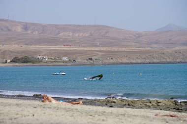 Matas Körfezi 'ndeki Atlantik Okyanusu' nda rüzgar sörfü ve jet ski görülmektedir. Rüzgâr sörfü, yelkencilik ve sörfün bir kombinasyonu olan rüzgar güdümlü bir su sporudur. Costa Calma, Fuerteventura, Las Palmas, Kanarya Adaları, İspanya. 