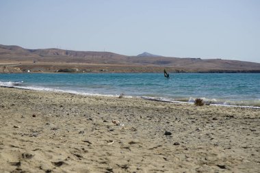 Bir rüzgar sörfçüsü, Matas Körfezi 'nde Atlantik Okyanusu' nun dalgalarında yelkenliyle sörf yapıyor. Rüzgâr sörfü, yelkencilik ve sörfün bir kombinasyonu olan rüzgar güdümlü bir su sporudur. Costa Calma, Fuerteventura, Las Palmas, Kanarya Adaları, İspanya.