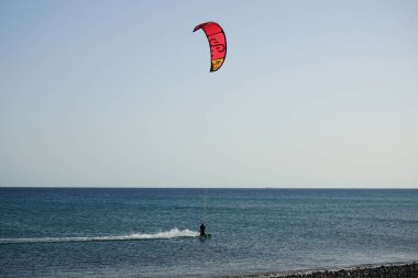 Bir uçurtma sörfçüsü, Matas Bay 'de, Matas de Blancas plajı boyunca sonbaharda Atlantik Okyanusu' nun dalgaları üzerinde sörf tahtasına biner. Uçurtma sörfü ya da uçurtma uçurmak rüzgar enerjisi gerektiren bir spordur. Costa Calma, Fuerteventura, Kanarya Adaları. 
