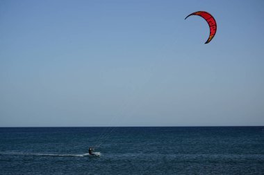 Bir uçurtma sörfçüsü, Matas Bay 'de, Matas de Blancas plajı boyunca sonbaharda Atlantik Okyanusu' nun dalgaları üzerinde sörf tahtasına biner. Uçurtma sörfü ya da uçurtma uçurmak rüzgar enerjisi gerektiren bir spordur. Costa Calma, Fuerteventura, Kanarya Adaları.  