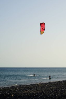 Bir uçurtma sörfçüsü, Matas Bay 'de, Matas de Blancas plajı boyunca sonbaharda Atlantik Okyanusu' nun dalgaları üzerinde sörf tahtasına biner. Uçurtma sörfü ya da uçurtma uçurmak rüzgar enerjisi gerektiren bir spordur. Costa Calma, Fuerteventura, Kanarya Adaları. 