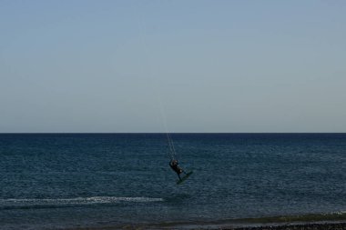 Bir uçurtma sörfçüsü, Matas Bay 'de, Matas de Blancas plajı boyunca sonbaharda Atlantik Okyanusu' nun dalgaları üzerinde sörf tahtasına biner. Uçurtma sörfü ya da uçurtma uçurmak rüzgar enerjisi gerektiren bir spordur. Costa Calma, Fuerteventura, Kanarya Adaları. 