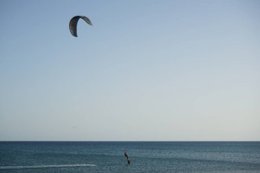 Bir uçurtma sörfçüsü, Matas Bay 'de, Matas de Blancas plajı boyunca sonbaharda Atlantik Okyanusu' nun dalgaları üzerinde sörf tahtasına biner. Uçurtma sörfü ya da uçurtma uçurmak rüzgar enerjisi gerektiren bir spordur. Costa Calma, Fuerteventura, Kanarya Adaları. 