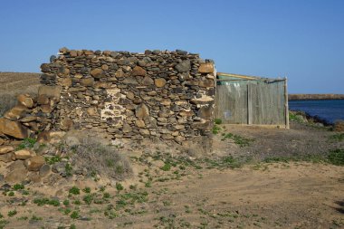 Eski binaların kalıntıları Ekim ayında Kosta Calma yakınlarındaki Matas Körfezi 'nde Atlantik Okyanusu kıyısında yer almaktadır. Fuerteventura, Las Palmas, Kanarya Adaları, İspanya. 