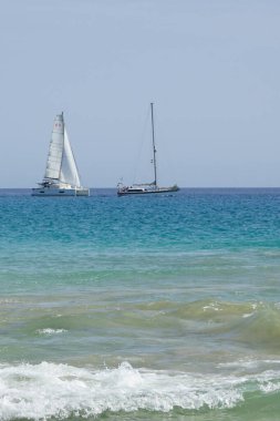 Ekim 'de Playa del Matorral plajı boyunca Atlantik Okyanusu' nda yelkenliler denize açılır. Morro Jable, Jandia, Fuerteventura, Las Palmas, Kanarya Adaları, İspanya. 