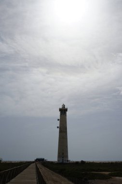 Morro Jable deniz feneri Faro de Morro Jable 'ın üzerinde güneş, Ekim ayında Morro Jable Atlantik kıyısında parlar. Morro Jable İspanya 'nın Kanarya Adaları' nın Fuerteventura adasında yer alan Pajara belediyesine bağlı bir yerleşim yeridir.. 