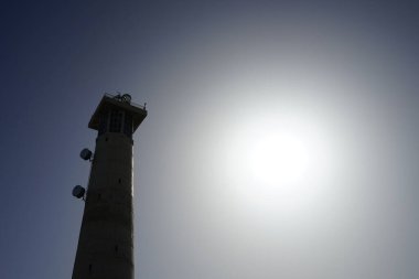 Morro Jable deniz feneri Faro de Morro Jable 'ın üzerinde güneş, Ekim ayında Morro Jable Atlantik kıyısında parlar. Morro Jable İspanya 'nın Kanarya Adaları' nın Fuerteventura adasında yer alan Pajara belediyesine bağlı bir yerleşim yeridir.. 