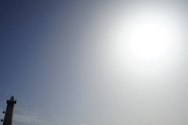 Morro Jable deniz feneri Faro de Morro Jable 'ın üzerinde güneş, Ekim ayında Morro Jable Atlantik kıyısında parlar. Morro Jable İspanya 'nın Kanarya Adaları' nın Fuerteventura adasında yer alan Pajara belediyesine bağlı bir yerleşim yeridir.. 