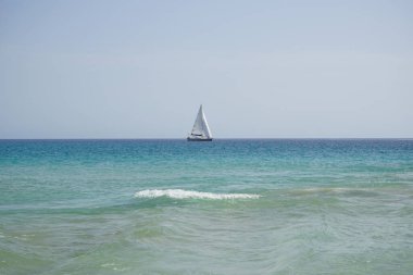 Atlantik Okyanusu 'nda, Playa del Matorral plajı boyunca, Ekim ayında, Fuerteventura, Las Palmas, Kanarya Adaları, İspanya' daki Morro Jable adasında bir yelkenli yatı seyreder..