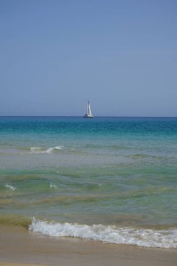 Atlantik Okyanusu 'nda, Playa del Matorral plajı boyunca, Ekim ayında, Fuerteventura, Las Palmas, Kanarya Adaları, İspanya' daki Morro Jable adasında bir yelkenli yatı seyreder..