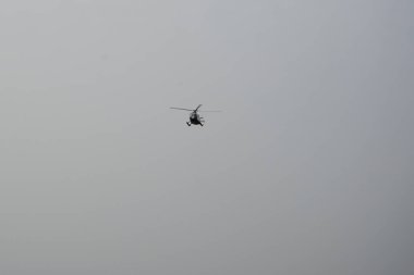 Bir helikopter, Tarajalejo tatil köyünün üstündeki bulutlu Ekim semalarında uçuyor. Helikopter, yatay dönen pervaneler tarafından desteklenen, kaldırma ve itme gücü olan bir rotorcraft türüdür. Tarajalejo, Tuineje, Fuerteventura, Kanarya Adaları. 
