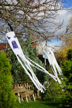 Cadılar Bayramı için uçan hayaletler Kasım ayında bahçeye yerleştirilir. Berlin, Almanya. 