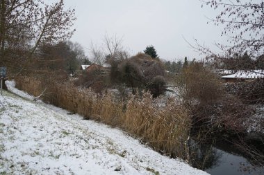Aralık ayında Wuhle Nehri yakınlarındaki bir dinlenme alanında güzel karlı bir manzara. Wuhle, Spree 'ye küçük bir sağ yaka haracı. Berlin, Almanya. 