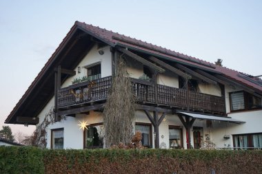 Bir Noel yıldızı ve yeni yıl çelenkleri Ocak ayında klasik Alman mimarisi ile bir evi süslüyor. Berlin, Almanya