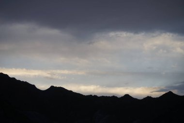 Nisan 'da gün batımında dağların üzerinden güzel bulutlu gökyüzü manzarası. Khor Fakkan, Sharjah, Birleşik Arap Emirlikleri. 