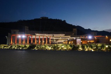 Khor Fakkan, Sharjah, Birleşik Arap Emirlikleri - 18 Nisan 2023: KHORFAKKAN AMPHITHEATRE şeklinde çiçek yatakları akşam saatlerinde Amfitiyatrosu önünde yer almaktadır..