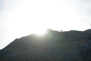 Nisan 'da Khor Fakkan kentinde dağın arkasında batan güneş gözlemlenir. Şeriat, Birleşik Arap Emirlikleri. 