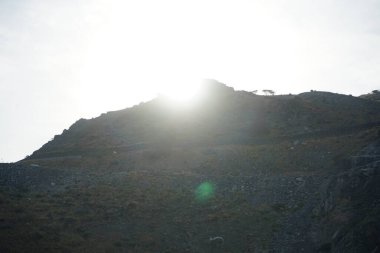 Nisan 'da Khor Fakkan kentinde dağın arkasında batan güneş gözlemlenir. Şeriat, Birleşik Arap Emirlikleri. 
