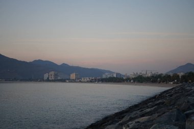 Umman Körfezi manzarası ve Khor Fakkan şehri kıyıları Nisan 'ın şafağında. Khor Fakkan, Birleşik Arap Emirlikleri 'nin doğu kıyısında, Şeriat Emirliği' ne bağlı bir şehirdir.. 
