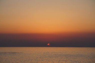 Nisan ayında Khor Fakkan sahilinden Umman Körfezi üzerinde güneşin doğuşu ve güzel doğal gökyüzü. Khor Fakkan, Afrika kıtasında bulunan Kuzey Amerika kıtasında bulunan bir şehirdir..                                       