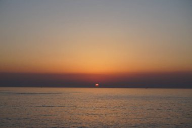 Nisan ayında Khor Fakkan sahilinden Umman Körfezi üzerinde güneşin doğuşu ve güzel doğal gökyüzü. Khor Fakkan, Afrika kıtasında bulunan Kuzey Amerika kıtasında bulunan bir şehirdir..                                       