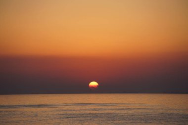 Nisan ayında Khor Fakkan sahilinden Umman Körfezi üzerinde güneşin doğuşu ve güzel doğal gökyüzü. Khor Fakkan, Afrika kıtasında bulunan Kuzey Amerika kıtasında bulunan bir şehirdir..  