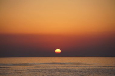 Nisan ayında Khor Fakkan sahilinden Umman Körfezi üzerinde güneşin doğuşu ve güzel doğal gökyüzü. Khor Fakkan, Afrika kıtasında bulunan Kuzey Amerika kıtasında bulunan bir şehirdir..  